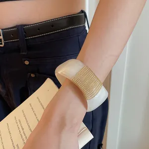 Λεπτομέρεια ακρυλικού βραχιολιού με χρυσό μεταλλικό πλέγμα στον καρπό ενός μοντέλου