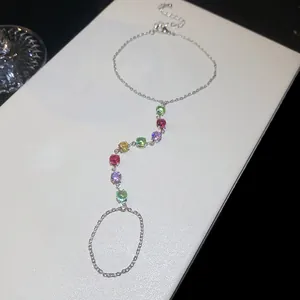 Détail d'un bracelet bague en argent orné de pierres de zircon multicolores