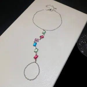 Détail d'un bracelet bague en argent orné de zircons colorés avec effet scintillant