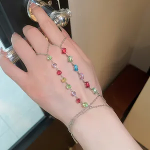 Vue détaillée d'un bracelet bague en zircons colorés avec pierres étincelantes sur la main