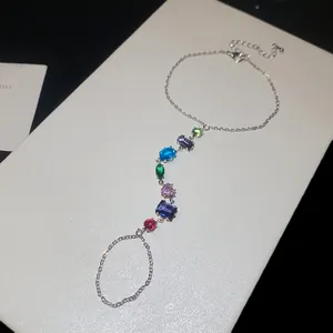 Détail d'un bracelet bague luxueux orné de zircons multicolores avec anneau intégré