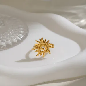 Detailansicht eines goldenen Edelstahl-Sonnenrings mit Spiralmuster auf einem Tablett