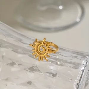 Detailansicht eines vergoldeten Edelstahlrings mit einem spiralförmigen Sonnendesign.