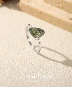 Primo piano di un anello in argento S925 con una pietra triangolare di agata muschiata verde.
