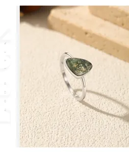 Primo piano di un anello d'argento con una pietra agata muschiata triangolare