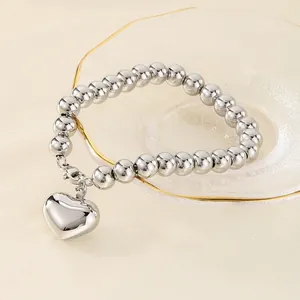 Bracelet à billes en acier inoxydable poli avec un pendentif en forme de cœur en 3D.