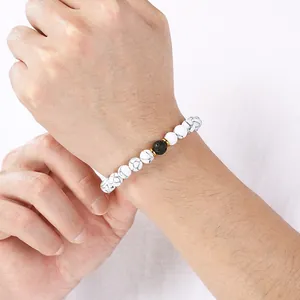 White turquoise and black lava stone elastic bracelet with gold stainless steel spacers.