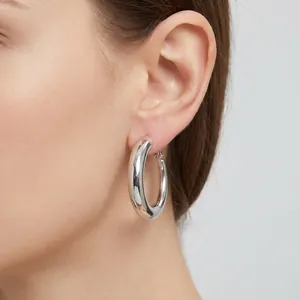 Gros plan de boucles d'oreilles créoles vintage en acier inoxydable argenté