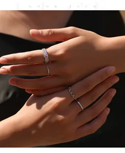 Primer plano de conjunto de anillos de plata y moissanita rosa en mano de modelo