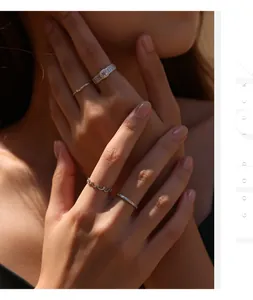 Vista detallada de manos femeninas con múltiples anillos de plata S925 y moissanita rosa