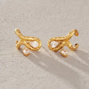 Detalle de pendientes de acero de titanio dorado con circonitas en forma de corazón