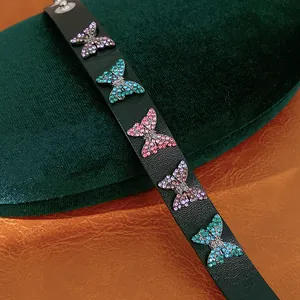 Vue détaillée d'un bracelet en cuir noir avec des breloques papillons en strass