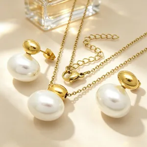 Close-up of elegant oval white shell pearls on a gold stainless steel jewelry set