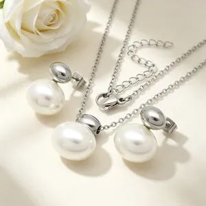 Detail view of simple white oval shell necklace and earrings set in stainless steel