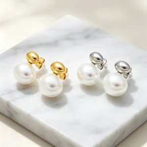 Close-up of minimalist stainless steel stud earrings with elegant white shell pearls
