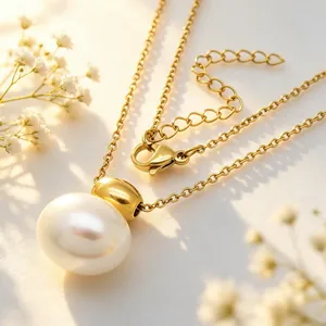 Macro detail shot of an elegant oval white shell pendant on gold stainless steel chain
