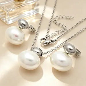 Close-up of minimalist stainless steel necklace and earring set with white oval shells