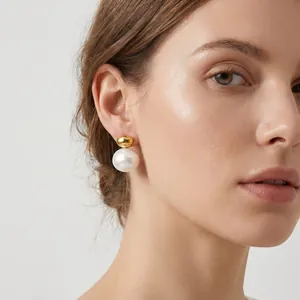Close-up view of minimalist stainless steel gold and white pearl earrings on model profile