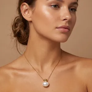 Close-up of minimalist oval white shell pendant on a gold stainless steel necklace