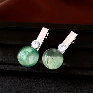 Nahaufnahme von Vintage-Haarspangen aus grünem Harz mit glitzernden Zirkon-Details