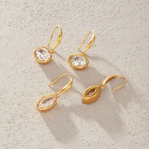 Vue détaillée de boucles d'oreilles en acier titane doré avec zircons brillants