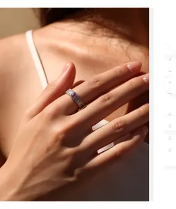 Primer plano de un elegante anillo de plata S925 con moissanita rosa en la mano con luz cálida