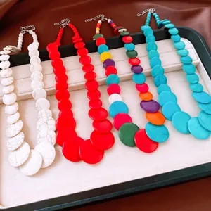 Close-up detail of colorful circular stone beaded necklaces in four vibrant styles.