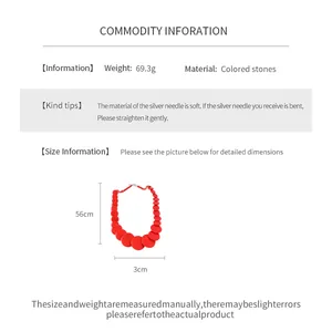 Macro view of a red beaded necklace showing weight, material and 56cm length measurements.
