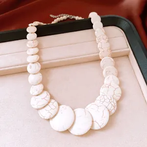 Macro shot of a white marbled stone beaded necklace showcased on a luxury jewelry tray