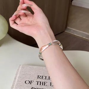 Vista detallada de una pulsera de resina elegante con segmentos claros y cuentas azules