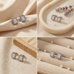 Vues rapprochées de boucles d'oreilles carrées en acier avec zircons blancs brillants.