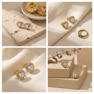 Vues détaillées de boucles d'oreilles cœur dorées avec zircon sur textures naturelles