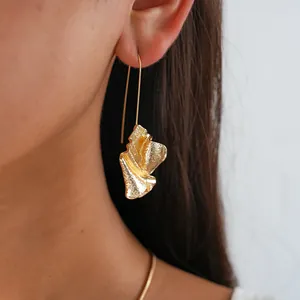 Detailed macro view of textured gold earrings worn on ear showing fine craftsmanship