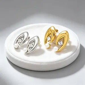 Détail des boucles d'oreilles œil du mal en or et argent avec perles et éclats de zircone