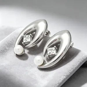 Vue rapprochée de boucles d'oreilles œil maléfique argentées avec perle et cristal