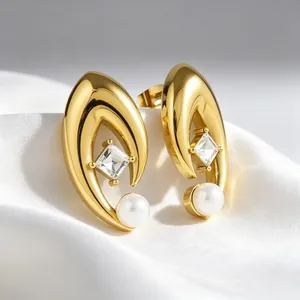 Détail de boucles d'oreilles en V dorées avec zircon carré et perles élégantes
