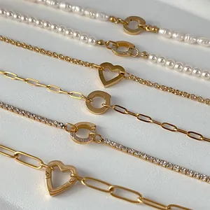 Chaînes dorées délicates avec perles d'eau douce et fermoirs en forme de cœur.