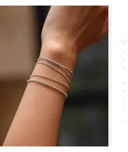 Elegant S925 sterling silver dainty link and beaded bracelets layered on a wrist