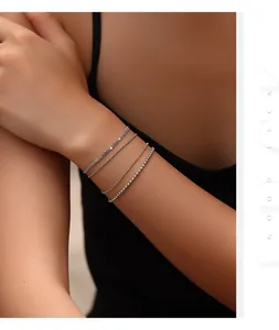Detailed view of four delicate S925 silver chain bracelets stacked on a woman's wrist.