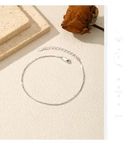 Detailed view of a minimalist S925 sterling silver thin bead chain bracelet on stone props.