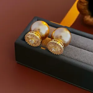 Gros plan de boucles d'oreilles géométriques vintage en zircon avec de grandes perles