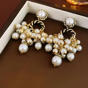 Gros plan de boucles d'oreilles pendantes en perles dorées vintage dans un bel écrin de luxe