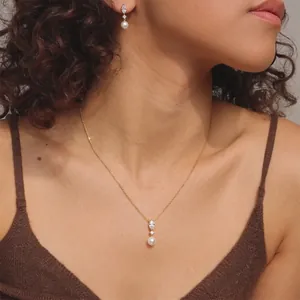 Nahaufnahme von 18K vergoldetem Marquise-Zirkonia und Perlen-Schmuckset an Model