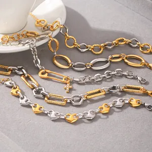 Macro detail of various stainless steel bi-color gold and silver bracelets on grey surface