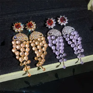 Close-up of elegant 18k gold plated grape drop earrings with sparkling cubic zirconia