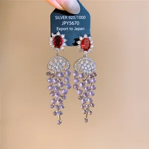 Close-up of 18k gold-plated zircon tassel earrings with purple grape-like beads