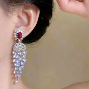Close-up of elegant 18k gold plated zircon tassel earrings worn by a model.