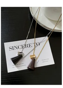 Vue détaillée de colliers avec pendentifs en cône de bois et accents métalliques