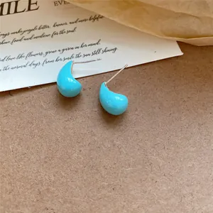 Gros plan de boucles d'oreilles gouttes turquoise élégantes avec finition émail lisse