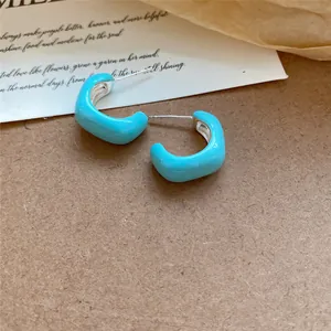 Vue détaillée de créoles en émail bleu clair au design géométrique très minimaliste.